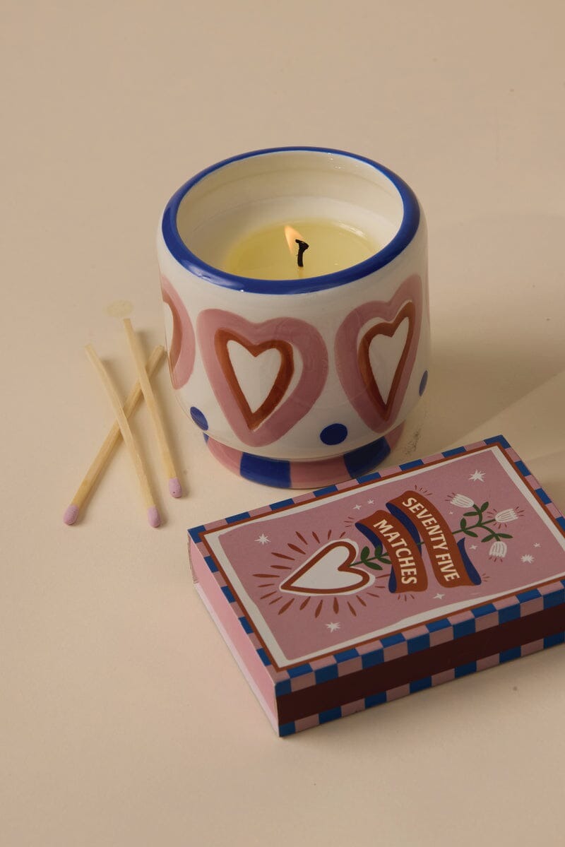 Vegan soy wax candle in ceramic heart jar with pink-tipped matches and decorative matchbox labeled seventy-five matches