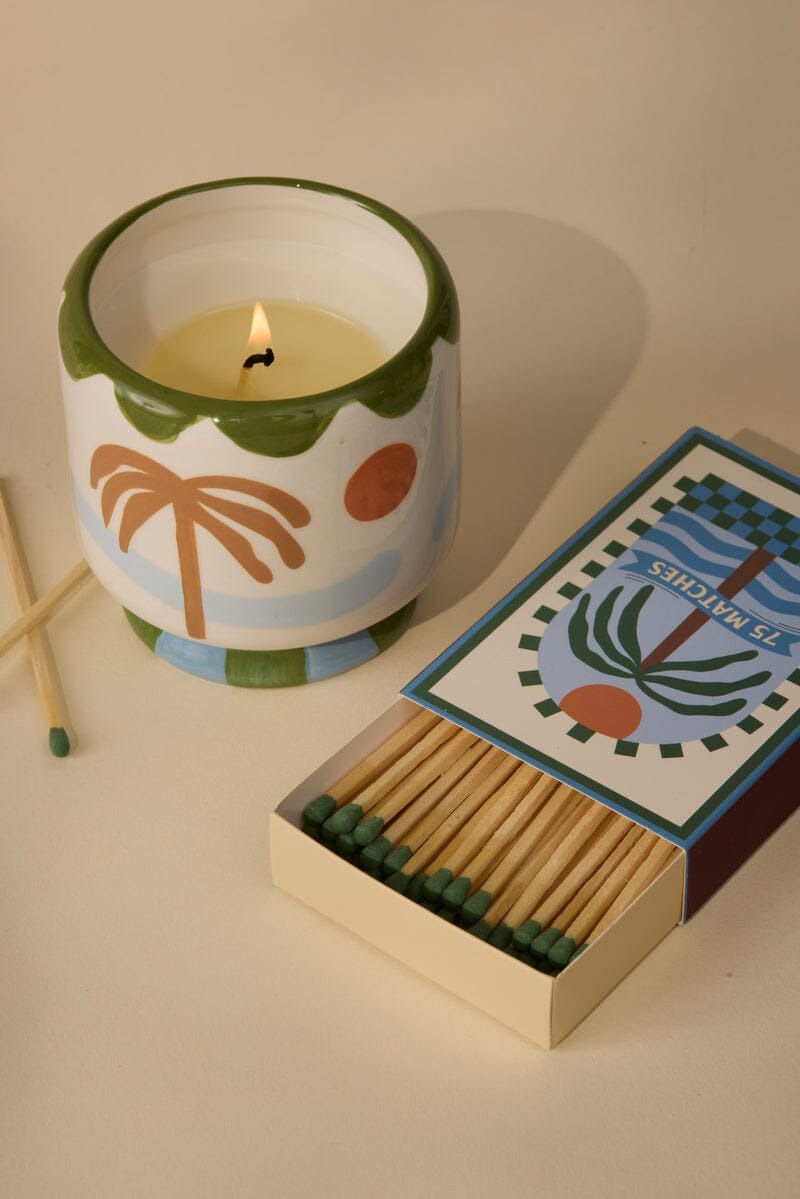 Vegan soy wax candle in ceramic heart jar with teal-tipped matches and decorative matchbox labeled seventy-five matches