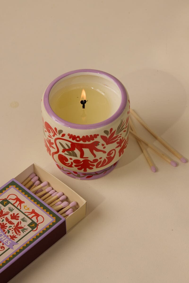 Vegan soy wax candle in ceramic monkey jar with lavender-tipped matches and decorative matchbox labeled seventy-five matches