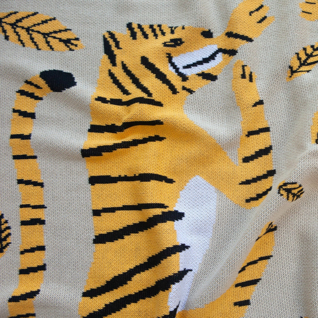 Close Up of the Big Cats Mini Blanket 30x40 inches, designed by James Daw, featuring two big cats and leaves, made from 50% cotton and 50% recycled polyester, soft and eco-friendly, made in USA