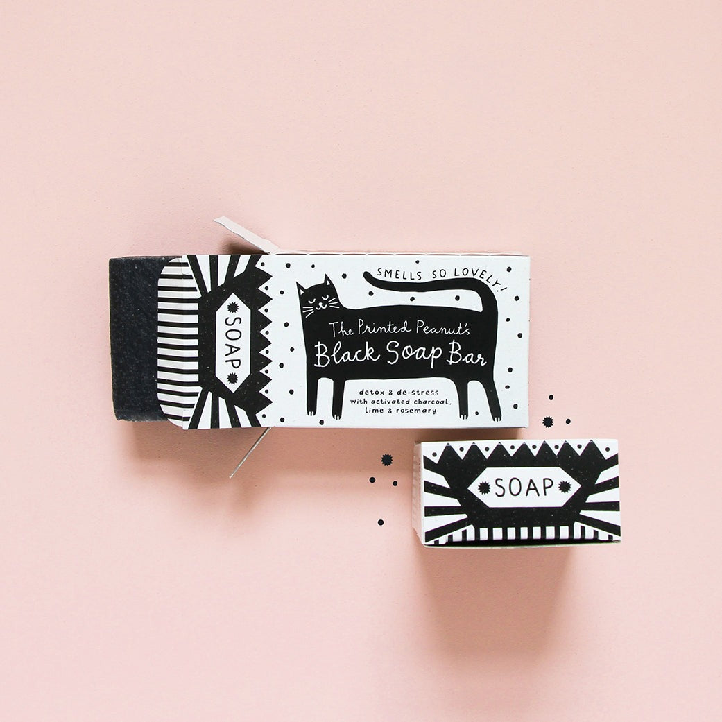 Black and white soap packaging with a cat illustration on a pink background