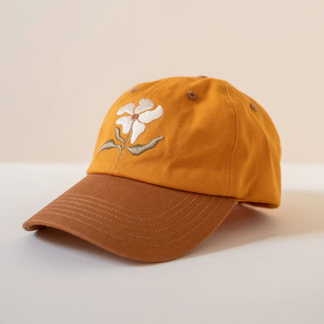 Orange cap with floral design on a beige background