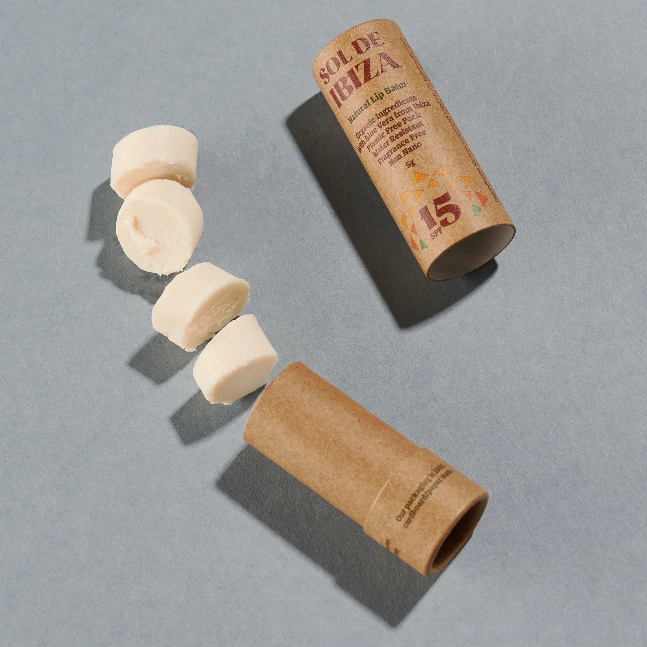 Open Lip Balm SPF15 with visible balm, in a compostable cardboard tube, shown on a grey background.