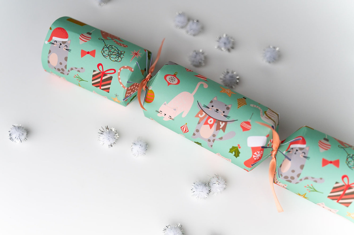 Cat Christmas crackers with festive designs on a white background