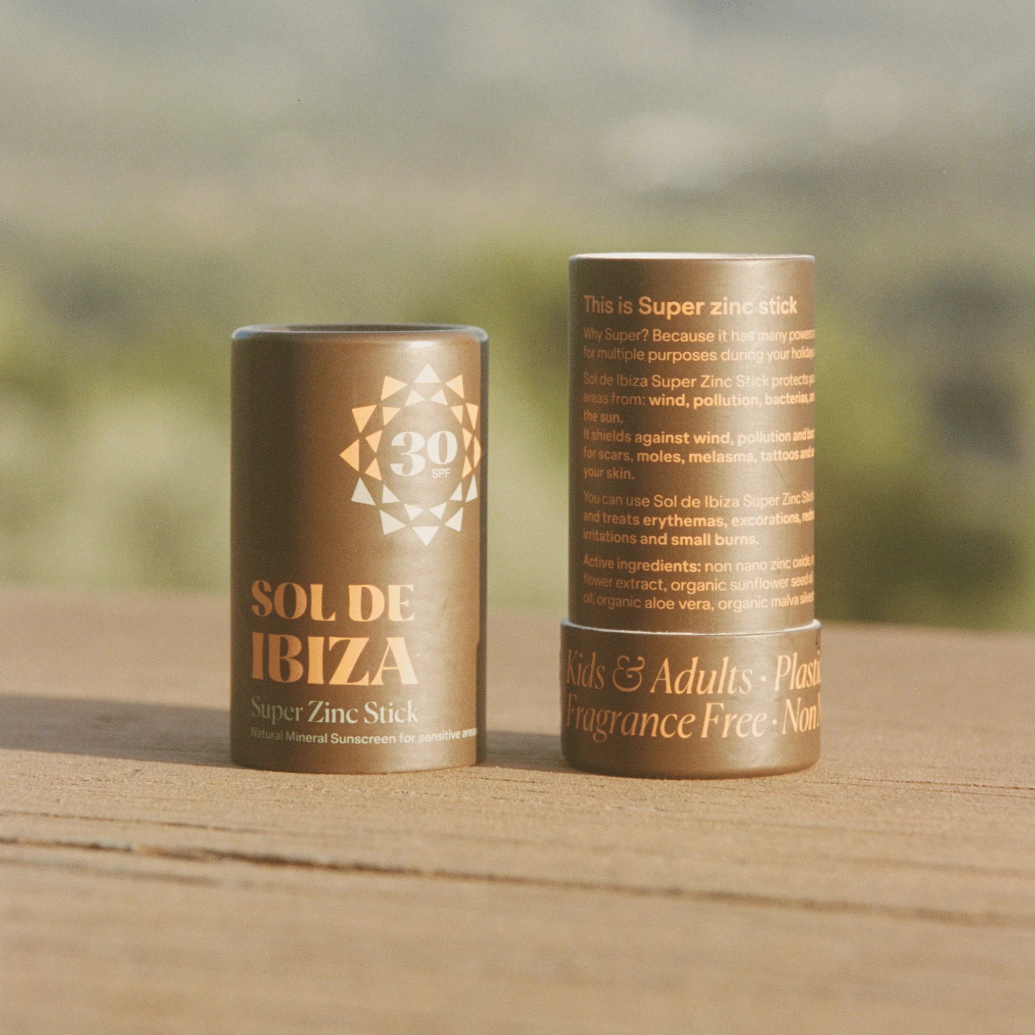 Two Sol de Ibiza super zinc sticks on a wooden surface with a blurred natural background