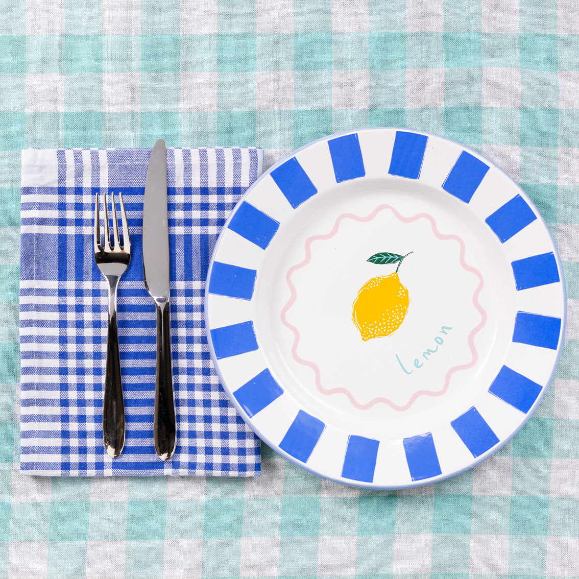 Lemon-themed enamel plate with blue stripes, pink wavy circle, and blue trim – 25cm, handcrafted and dishwasher safe