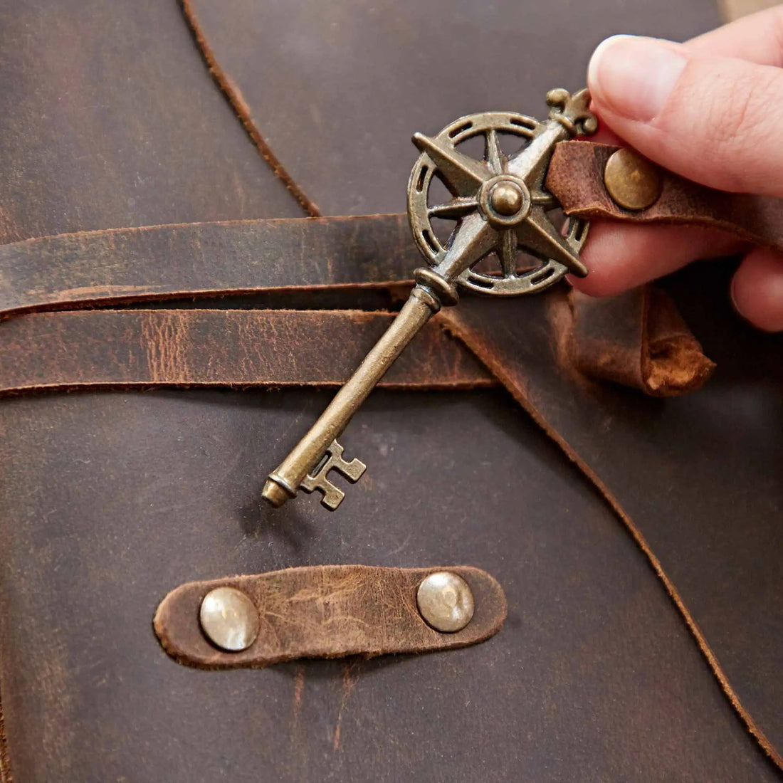 Close-up of the Dream Buffalo Leather Journal With A Key, highlighting the antique compass key and leather strap closure.