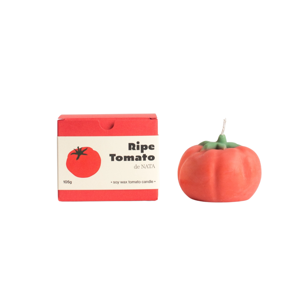 Tomato-shaped candle with packaging on a white background