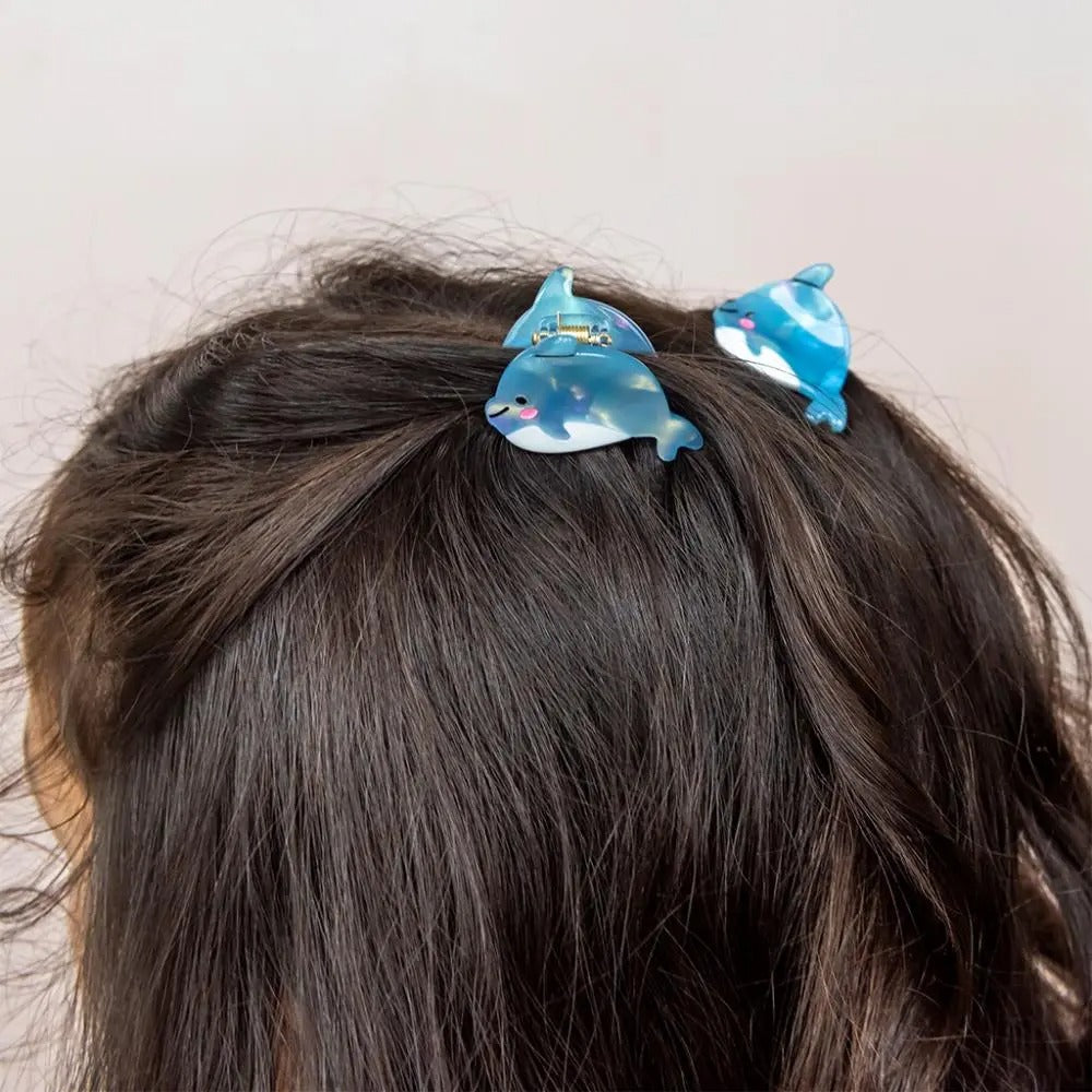 Two blue dolphin-shaped hair clips on a person&