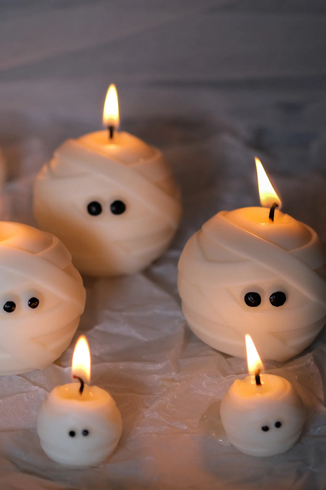 Group of Mummy Ghost Candles with candles on, sustainable soy wax Halloween ghost candles for spooky seasonal décor.