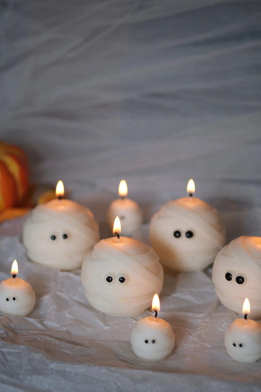 Group of Mummy Ghost Candles with candles on, sustainable soy wax Halloween ghost candles for spooky seasonal décor.