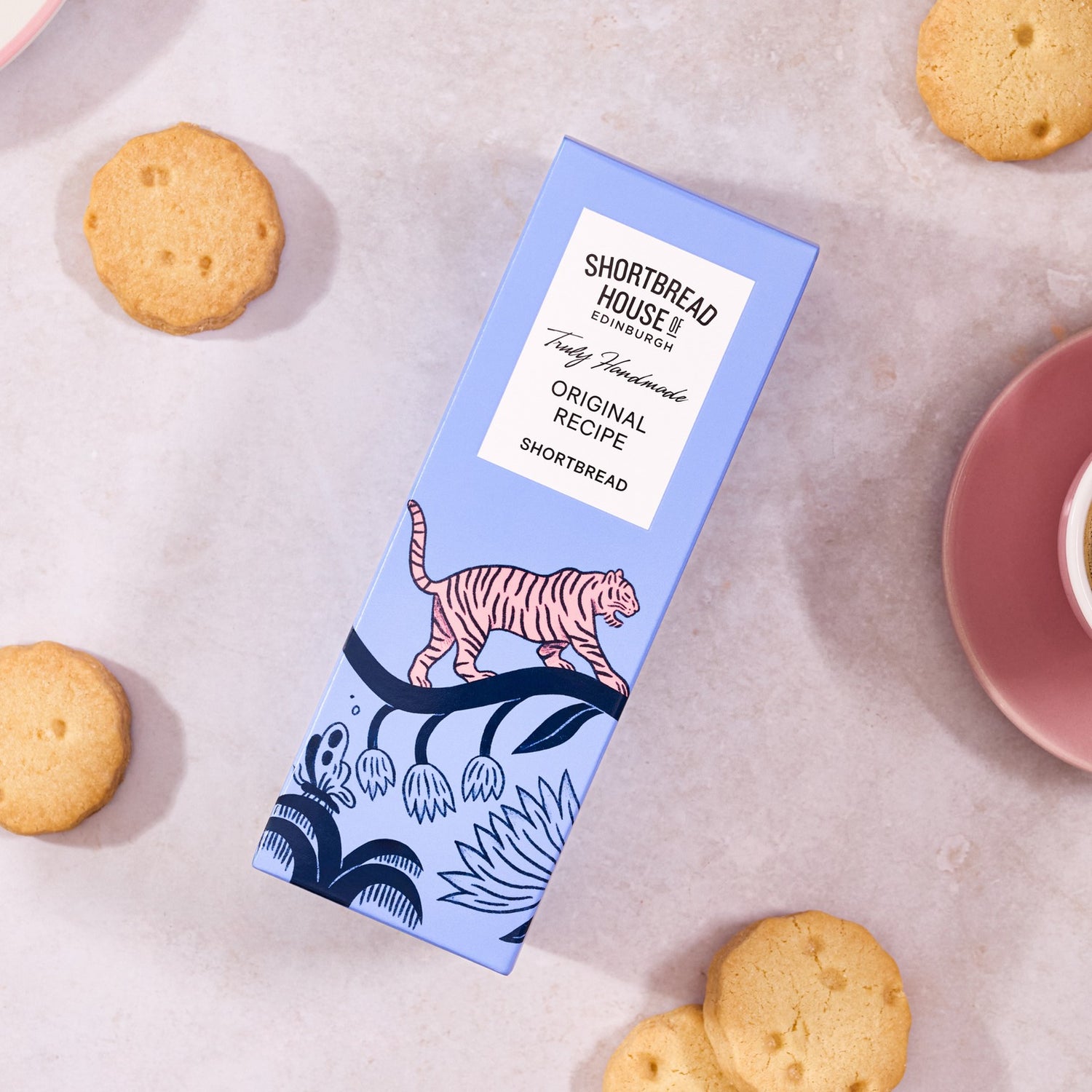 Shortbread box with tiger design on a surface with cookies