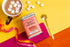 Spice Kitchen classic hot chocolate with mug, and marshmallow on orange and pink surface and yellow background – vegan dairy-free hot chocolate.