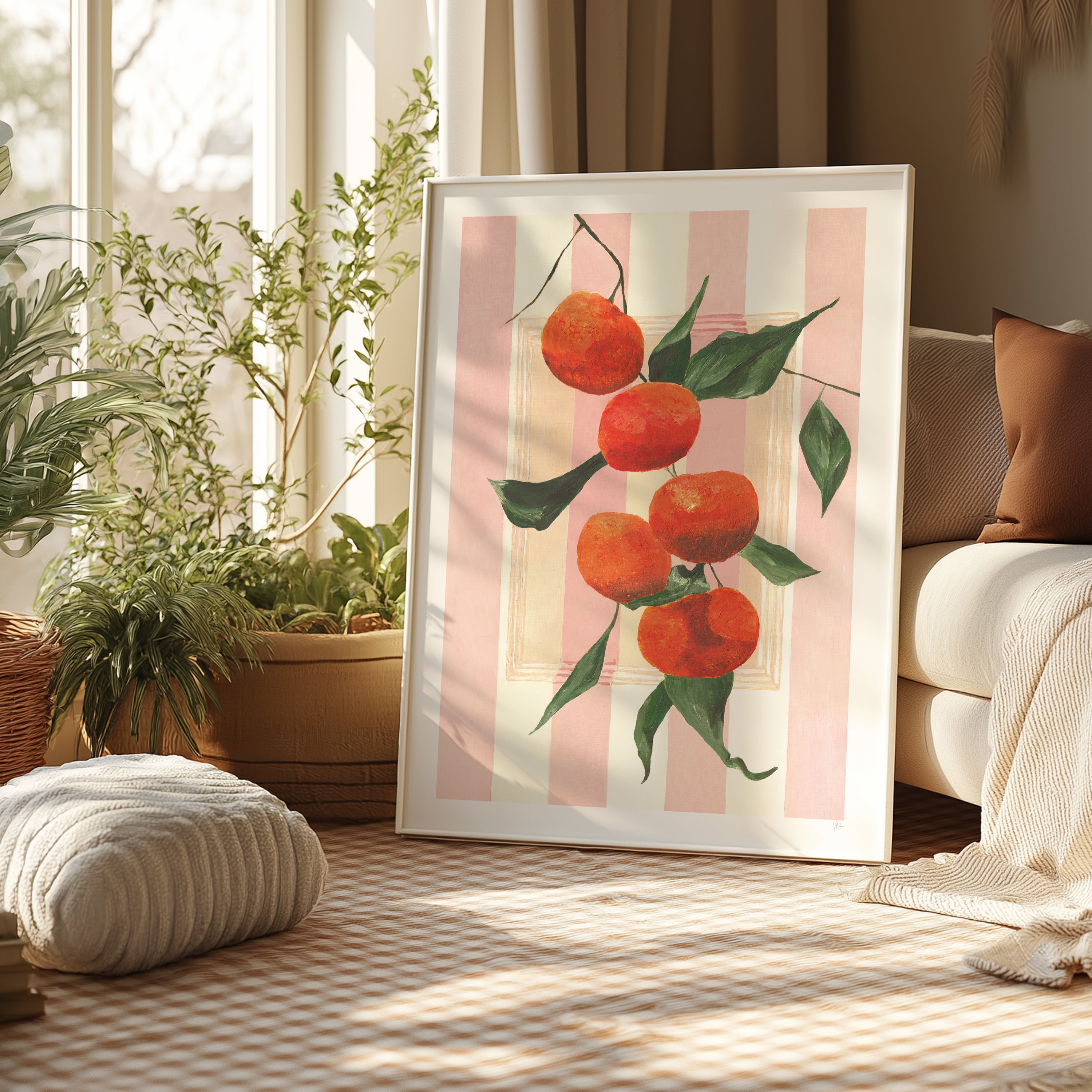 Framed artwork of oranges on a pink striped background in a living room.