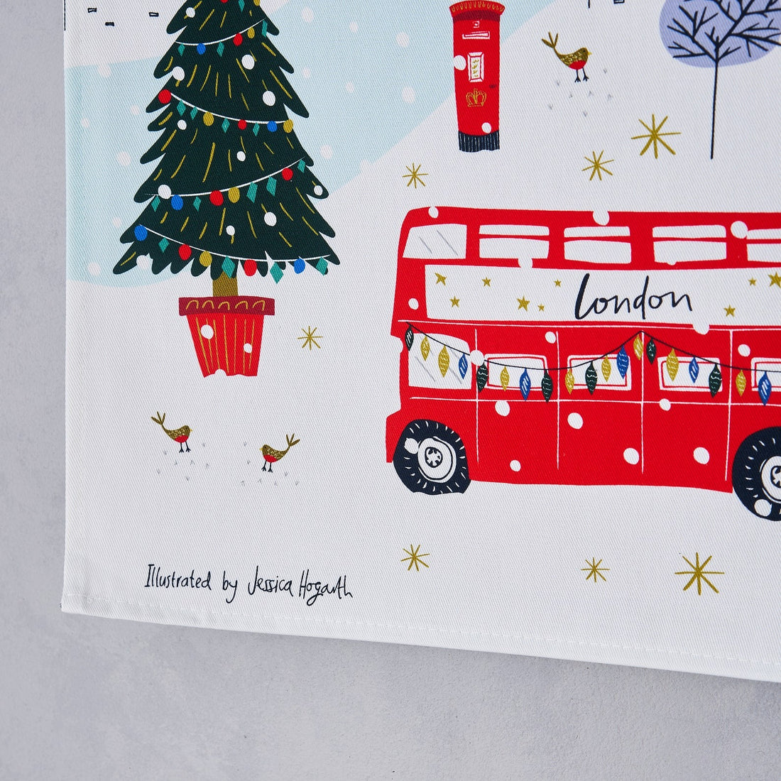 Close-up of the “Illustrated London tea towel with Tower Bridge and London Eye landmarks, 100% cotton, British-made, gift-ready packaging