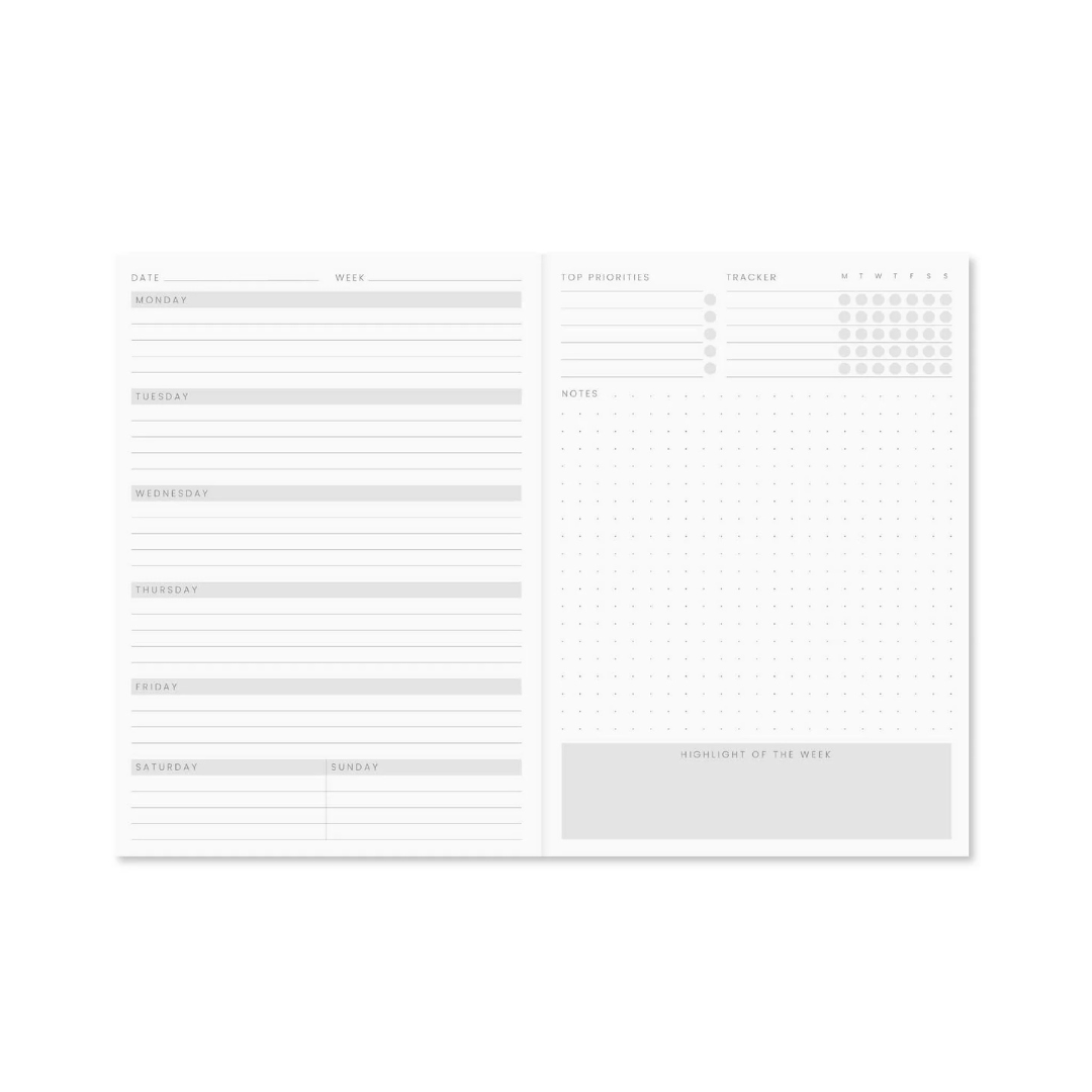 Open Reverie A5 Weekly Planner Pink Marble showing week-to-view layout with priorities, habit tracker, notes, and weekly highlight