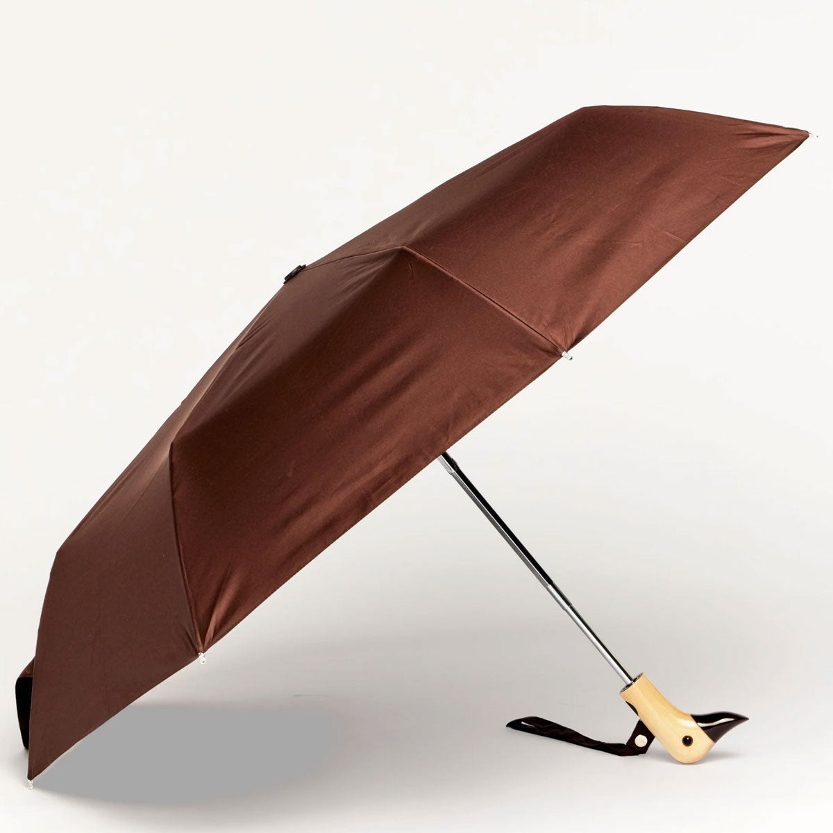 Close up Brown umbrella with a duck wooden handle on a light gray background