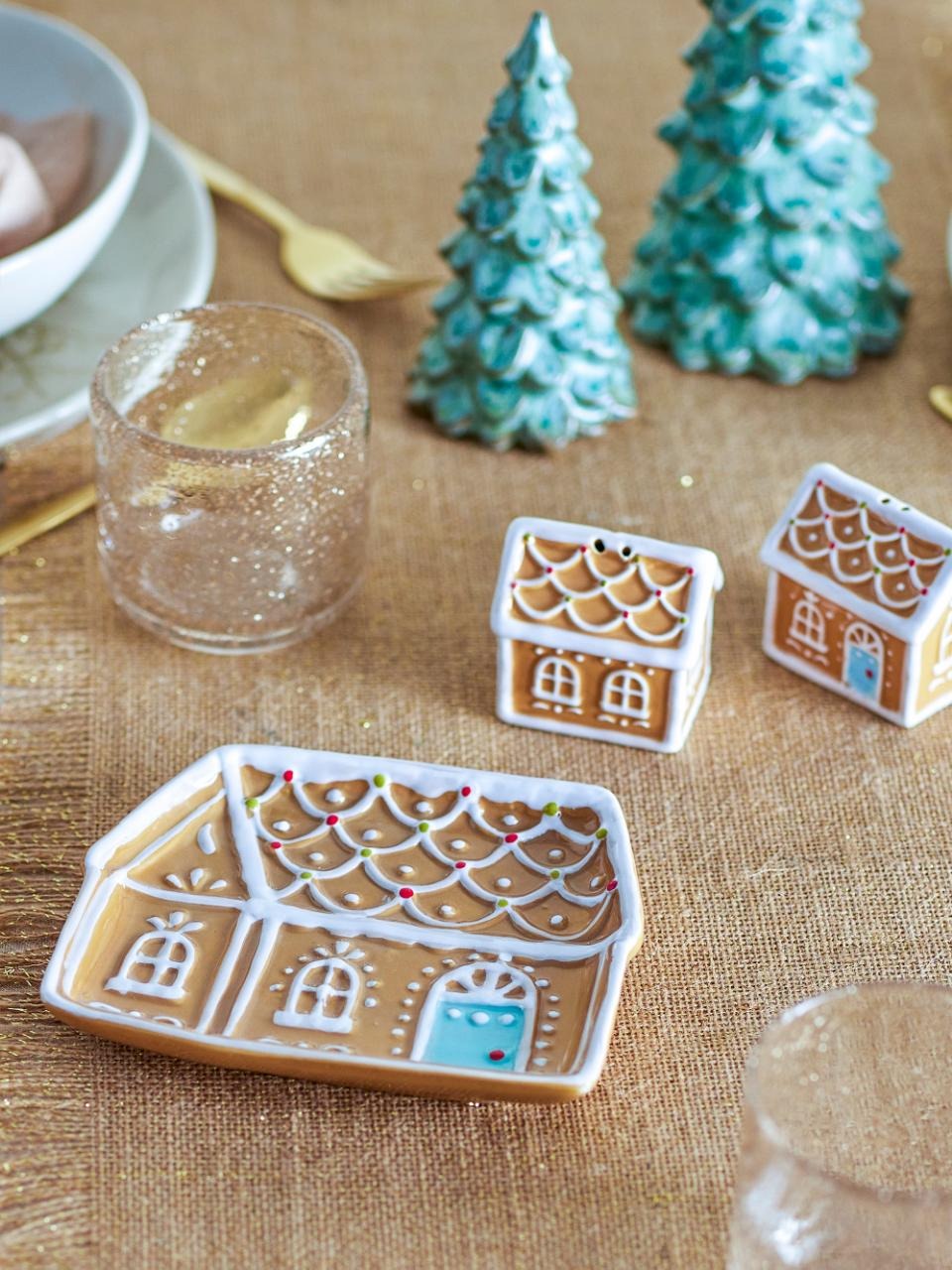 Hand-painted Ginnie Plate featuring a festive gingerbread house design, on a Christmas table setting