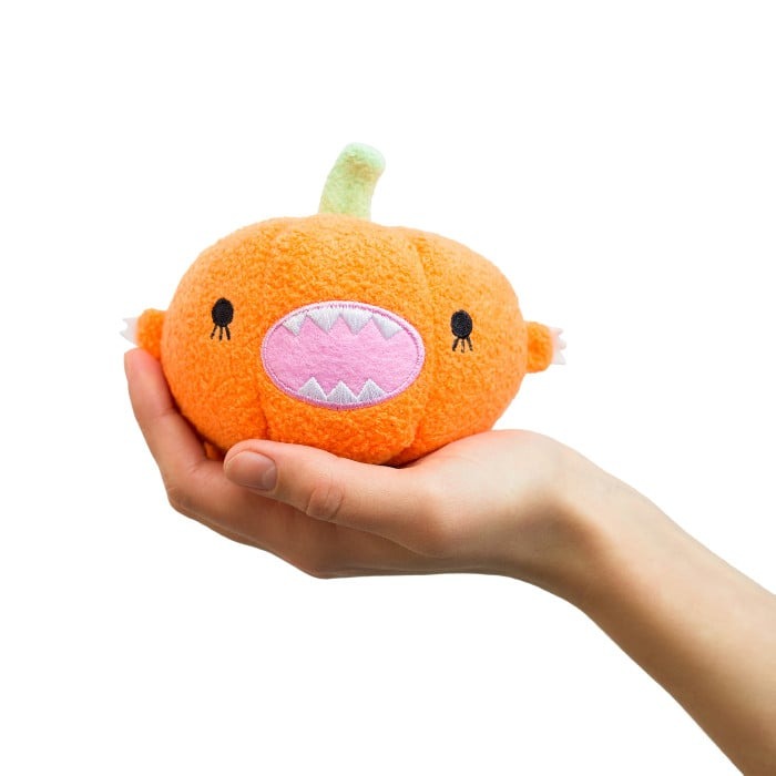 Ricepumpkin mini plush toy held in one hand, showcasing its small size, soft texture, and velcro strap.