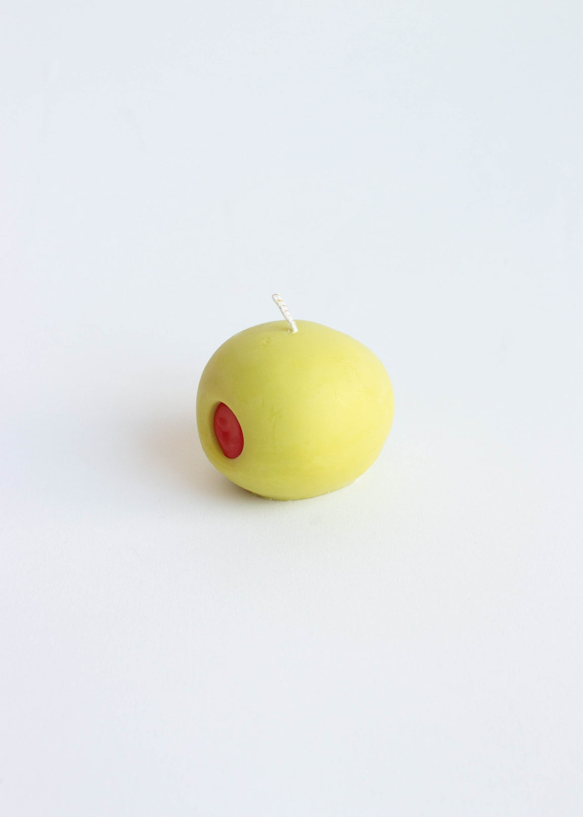 Green Olive candle with a red dot on a white background