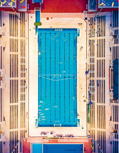 Top-down view of a swimming pool with lanes and starting blocks.