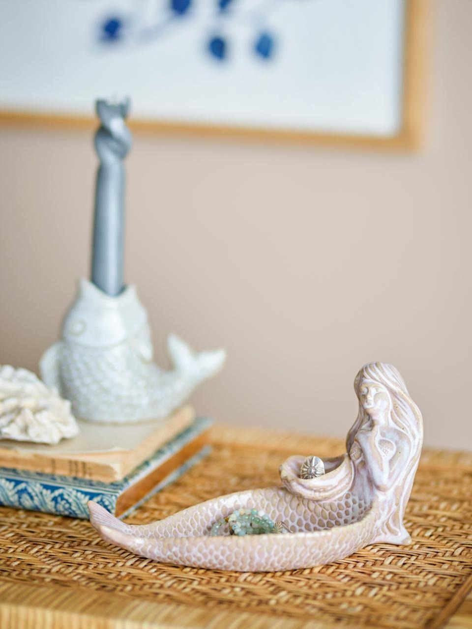 Decorative mermaid bowl on a woven surface with a blurred background