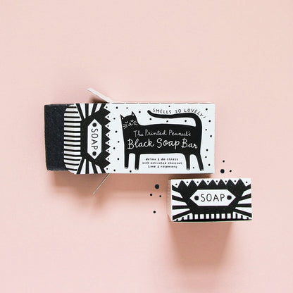 Black and white soap packaging with a cat illustration on a pink background