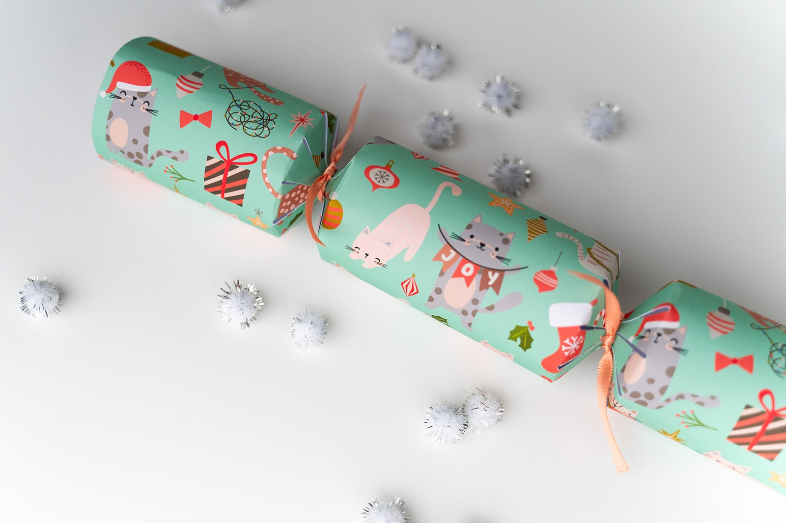 Cat Christmas crackers with festive designs on a white background