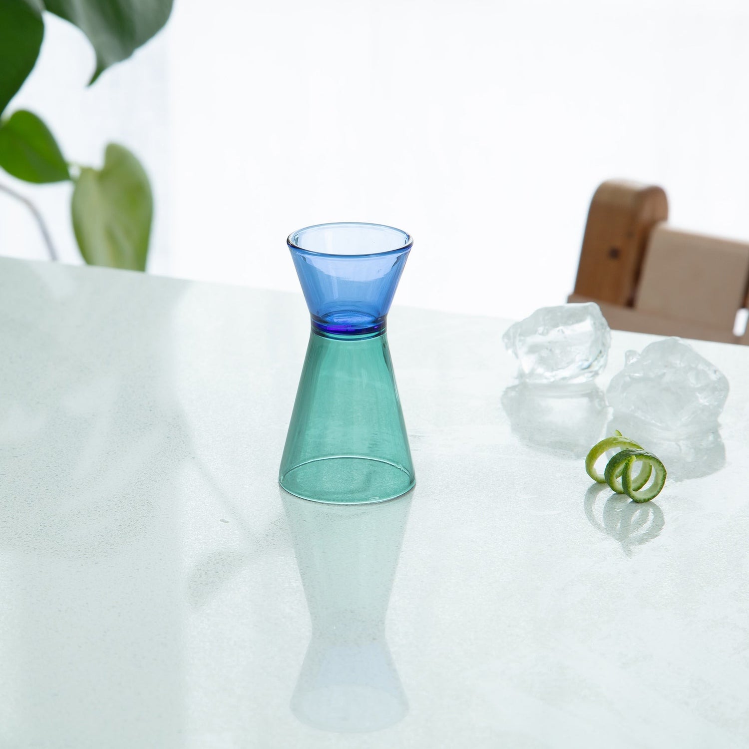 Duo Tone Cocktail Jigger on a white surface with a blurred background