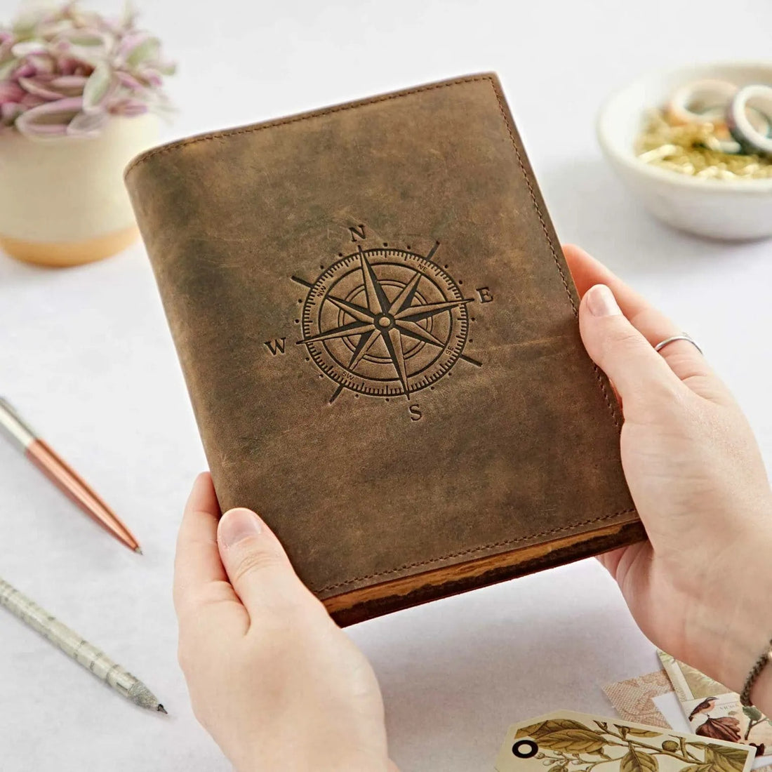 Compass Leather Journal held with two hands, showing its vintage leather cover and handcrafted design.