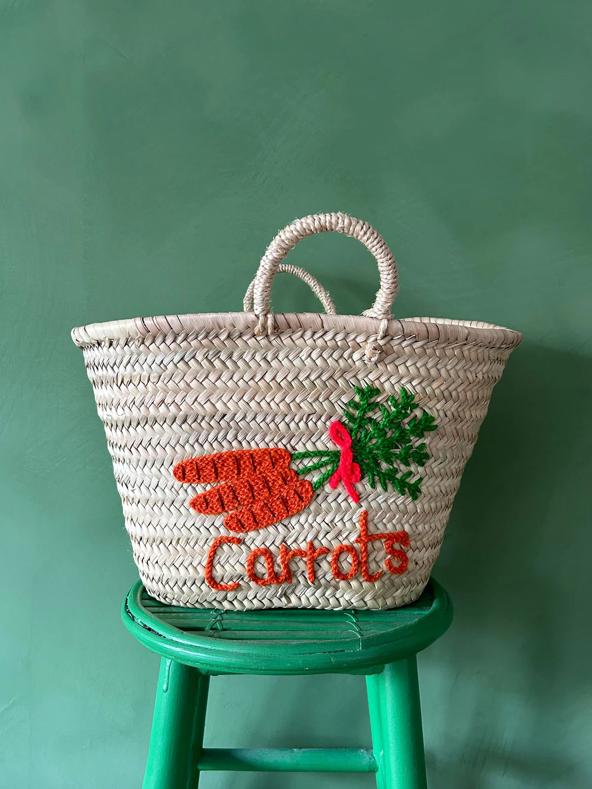 Handwoven palm leaf market basket with embroidered carrot design