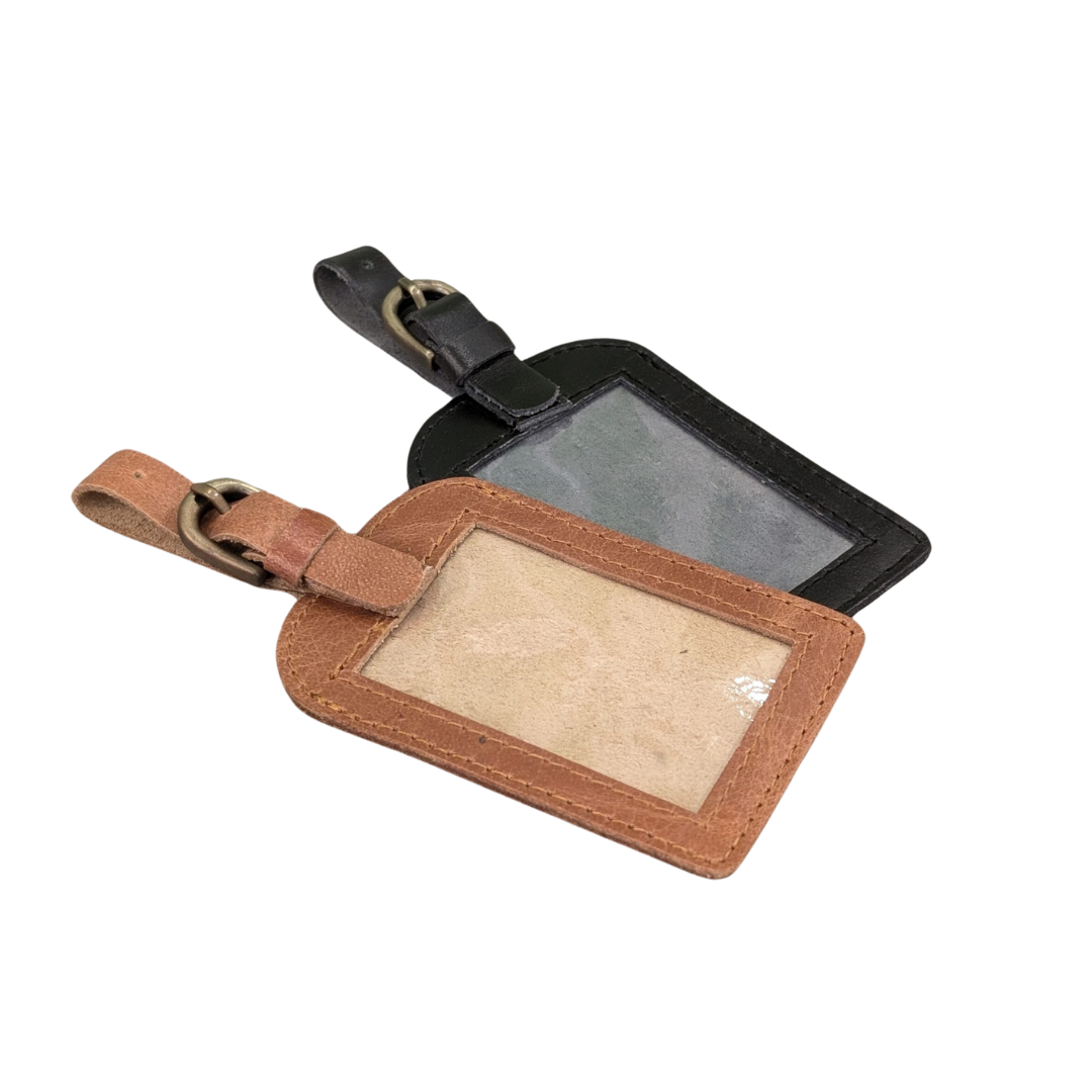 Brown and black leather luggage tag with a plastic insert on a white background