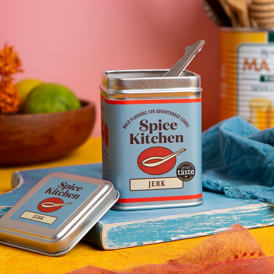 Spice Kitchen jerk spice can with a spoon on a colorful background