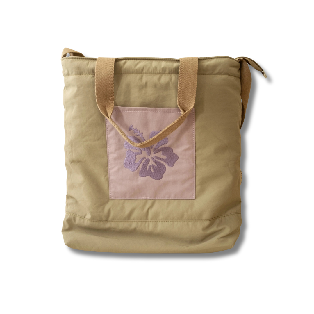 Olive green nylon beach tote with a floral embroidery on the front pocket and two
long handles.
