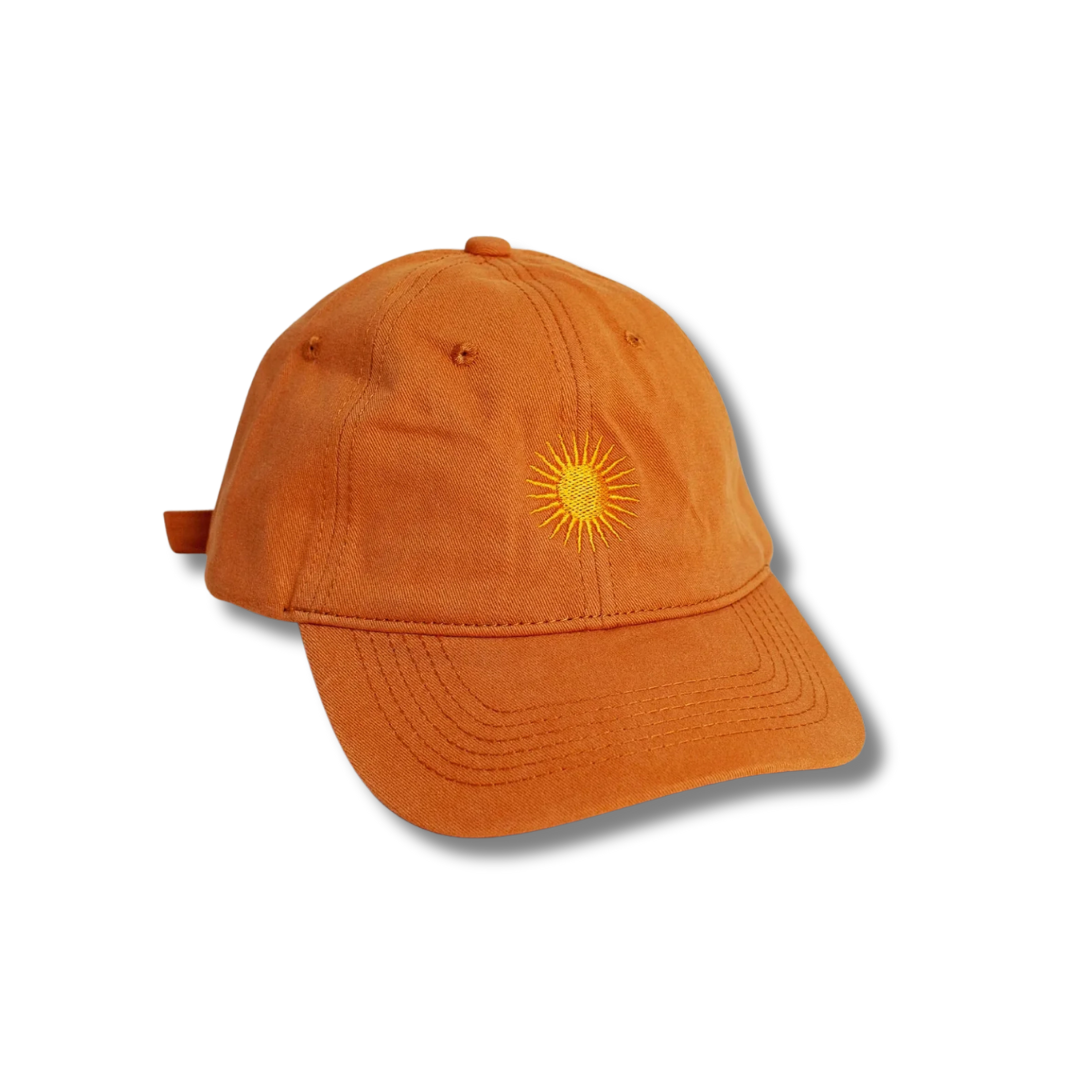 Orange cotton cap with gold embroidered sun design on the front, displayed against a white background