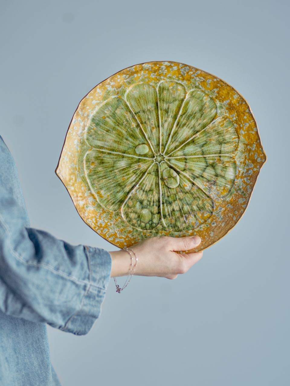 Person holding the milani serving plate gainst a plain background