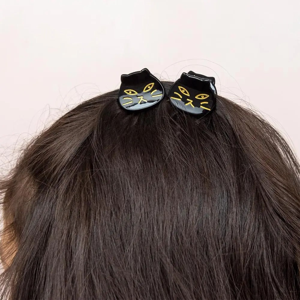 Two black cat hair clips on a person&