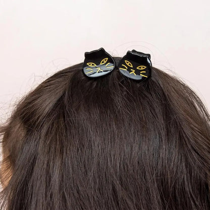 Two black cat hair clips on a person&