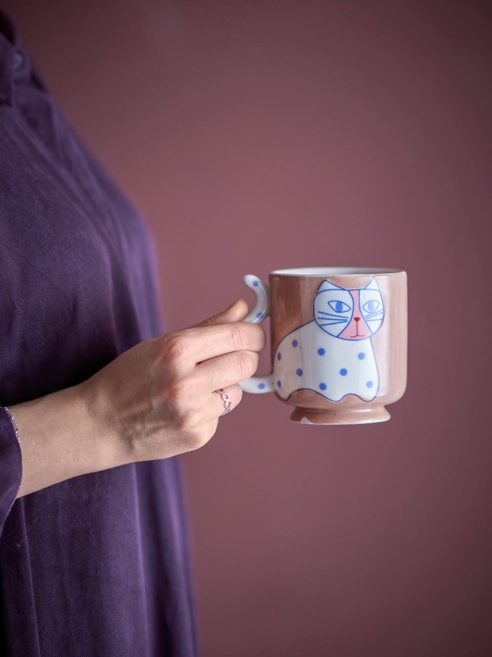Person holding the Missy mug against a pink background