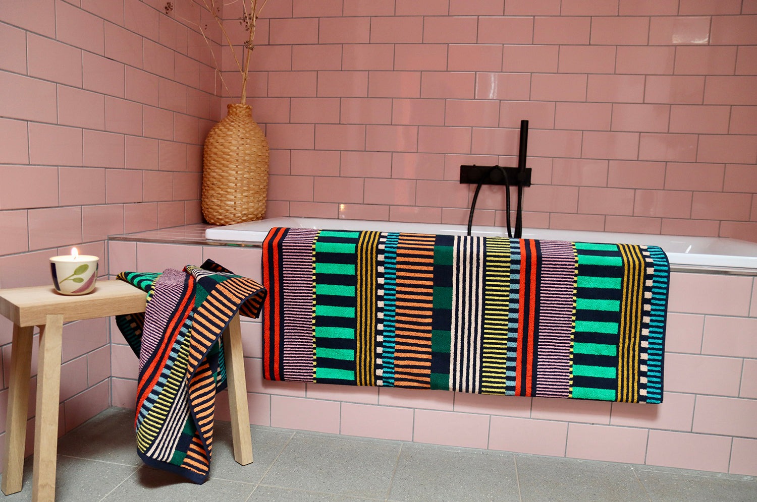 Multi Stripes Hand Towel and Multi Stripes Bath Towel with, colorful playful design, in a pink bathroom