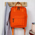 Compact everyday backpack in orange with adjustable straps and multiple compartments