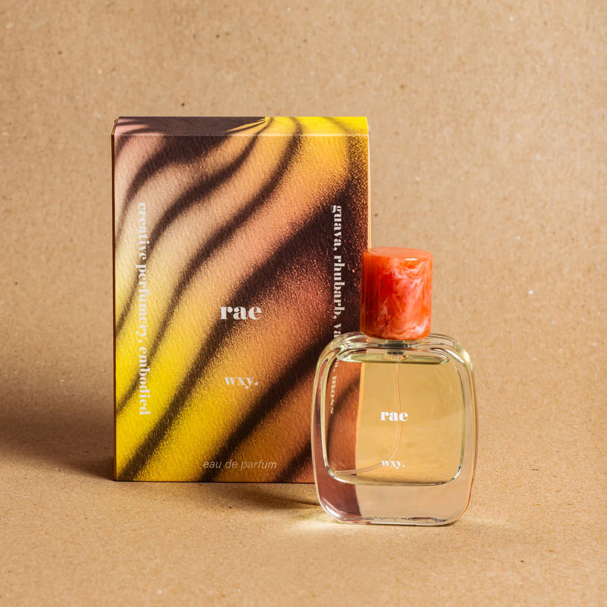 Rae Eau de Parfum bottle and packaging on a brown background  – vibrant tropical fragrance