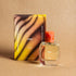 Rae Eau de Parfum bottle and packaging on a brown background  – vibrant tropical fragrance
