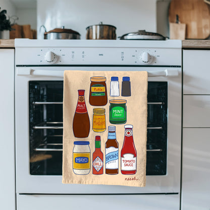 Kitchen towel with condiment illustrations hanging on a stove