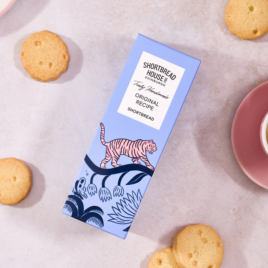 Shortbread box with tiger design on a surface with cookies