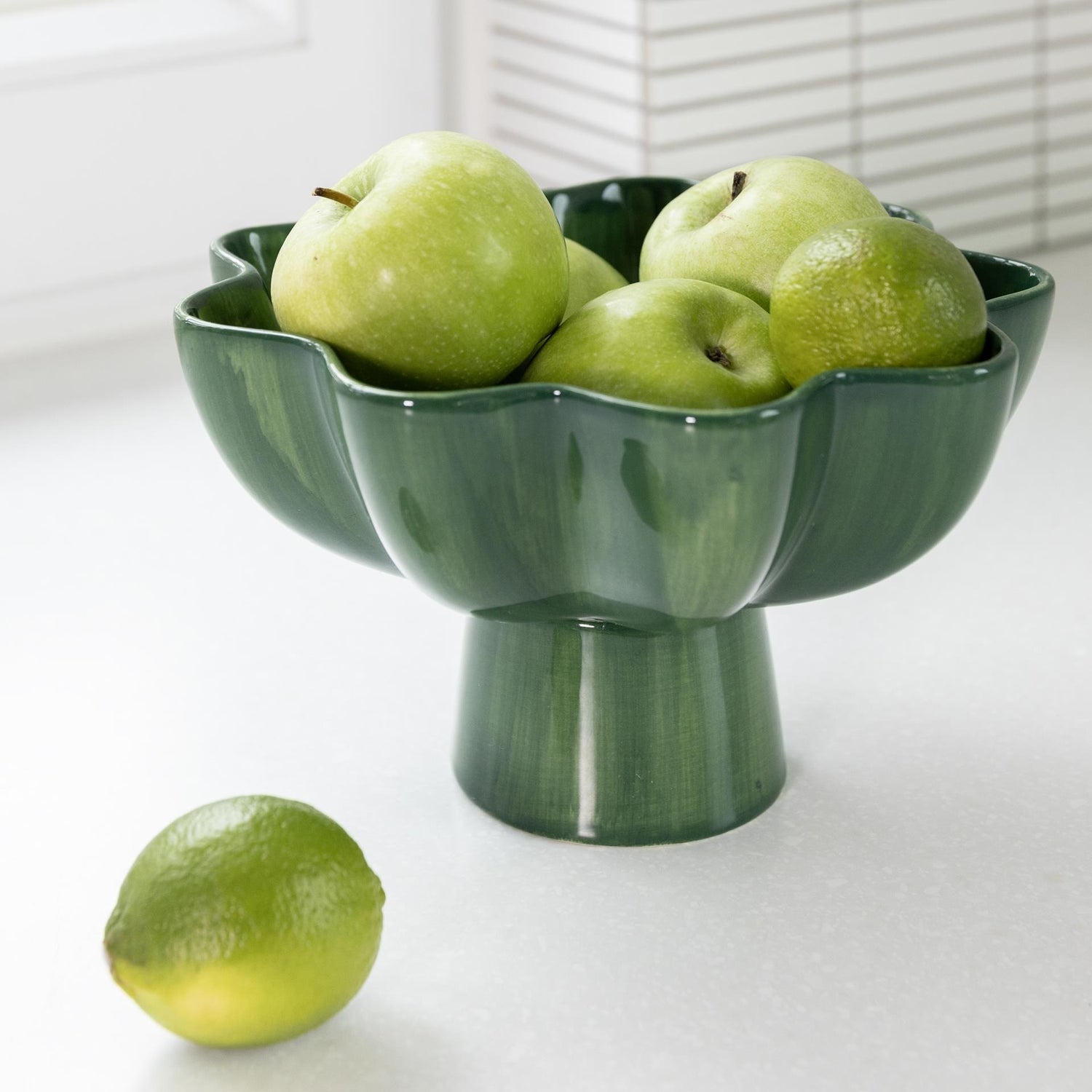 Sun Green Bowl made of stoneware, filled with green apples, showcasing its bold green color and modern design as a functional and decorative kitchen piece.