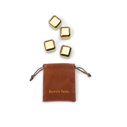 A set of stainless steel cocktail chillers in the form of freezable cubes, accompanied by a brown storage pouch with a drawstring closure