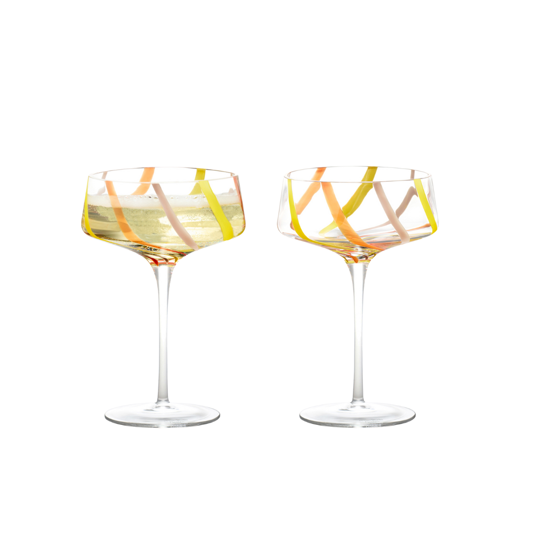 Two crystal-clear champagne glasses with swirls of pink, orange, and yellow colors, featuring long stems and rounded bowls.