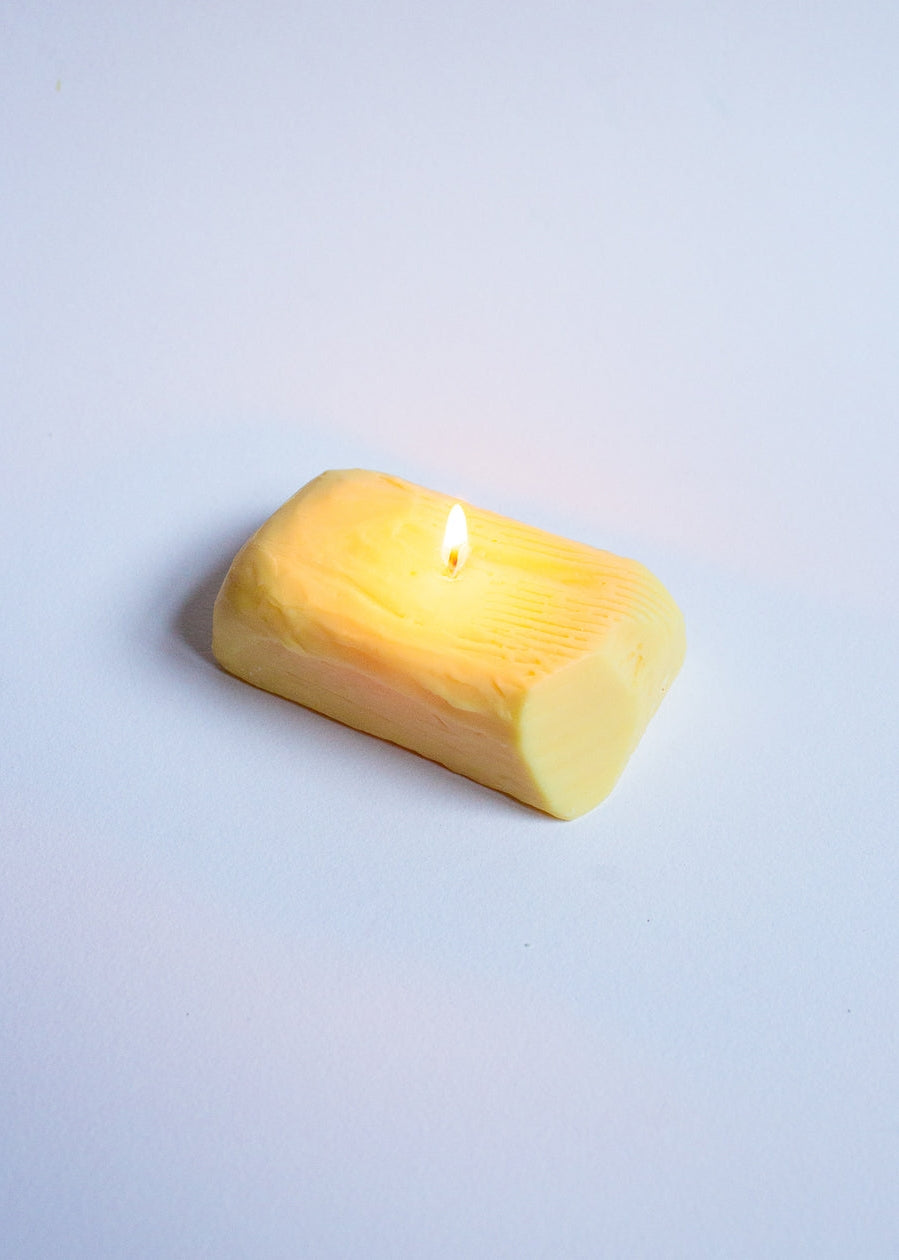  Butter candle with a lit wick on