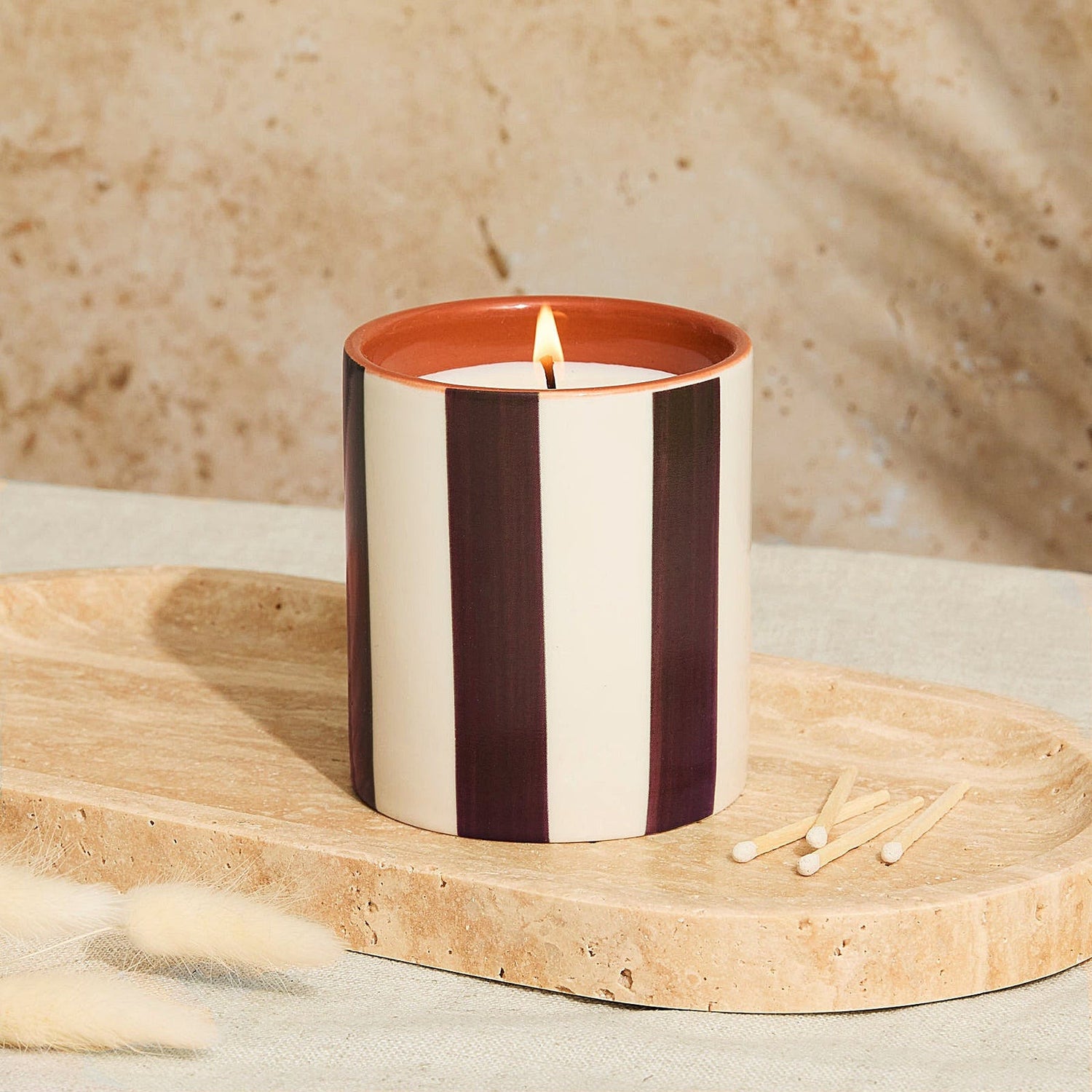 Lighting the Marrakesh ceramic tomato leaf candle with chocolate stripe design